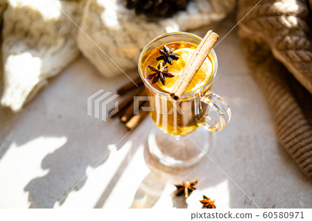 Hot winter drink with cinnamon and lemon on bright sunny day 60580971