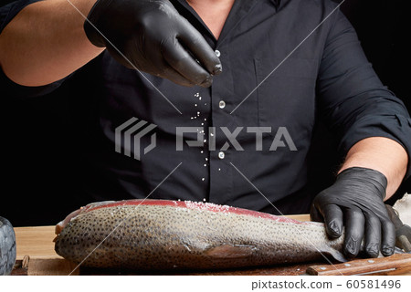 chef in a black shirt and black latex gloves 60581496