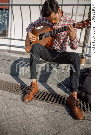 Street musician rehearsing a tune on the street 60581957