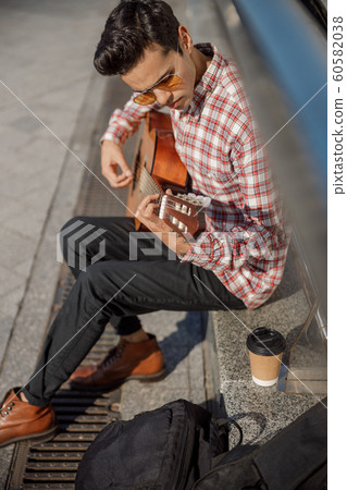 Male musician performing a song on the street 60582038