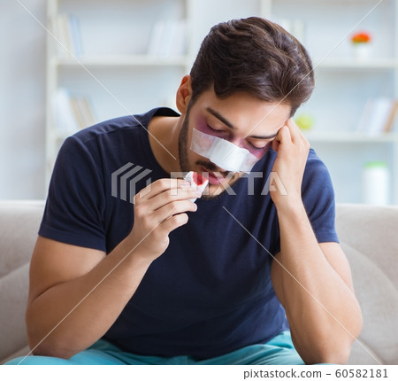 Young man recovering healing at home after plastic surgery nose 60582181