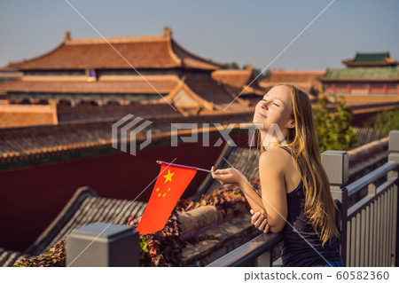 Enjoying vacation in China. Young woman with national chinese flag in Forbidden City. Travel to China concept. Visa free transit 72 hours, 144 hours in China Enjoying vacation in China. Young woman with national chinese flag in Forbidden City. Travel to China concept. Visa free transit 72 hours, 144 hours in China 60582360