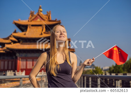 Enjoying vacation in China. Young woman with national chinese flag in Forbidden City. Travel to China concept. Visa free transit 72 hours, 144 hours in China 60582613