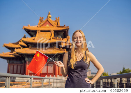 Enjoying vacation in China. Young woman with national chinese flag in Forbidden City. Travel to China concept. Visa free transit 72 hours, 144 hours in China Enjoying vacation in China. Young woman with national chinese flag in Forbidden City. Travel to China concept. Visa free transit 72 hours, 144 hours in China 60582669
