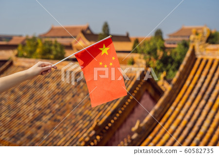 Enjoying vacation in China. Young woman with national chinese flag in Forbidden City. Travel to China concept. Visa free transit 72 hours, 144 hours in China 60582735