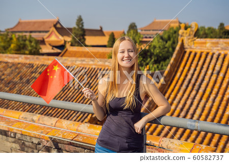 Enjoying vacation in China. Young woman with national chinese flag in Forbidden City. Travel to China concept. Visa free transit 72 hours, 144 hours in China 60582737