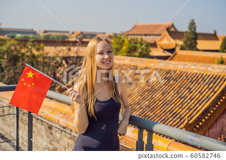 Enjoying vacation in China. Young woman with national chinese flag in Forbidden City. Travel to China concept. Visa free transit 72 hours, 144 hours in China 60582746