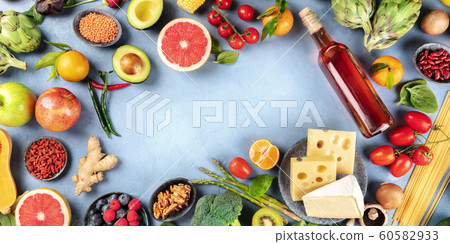 Food, overhead panoramic shot of vegetables and fruits, legumes, wine, pasta and cheese, forming a frame for copy space 60582933