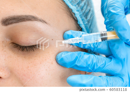 Close-up, beautician makes beauty injections into 60583118