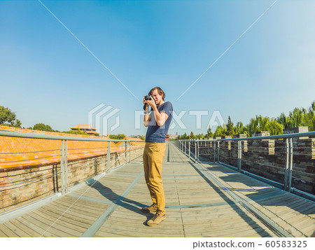 Enjoying vacation in China. Young man in Forbidden City. Travel to China concept. Visa free transit 72 hours, 144 hours in China Enjoying vacation in China. Young man in Forbidden City. Travel to China concept. Visa free transit 72 hours, 144 hours in China 60583325