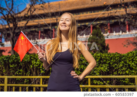 Enjoying vacation in China. Young woman with national chinese flag in Forbidden City. Travel to China concept. Visa free transit 72 hours, 144 hours in China 60583397
