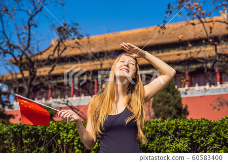 Enjoying vacation in China. Young woman with national chinese flag in Forbidden City. Travel to China concept. Visa free transit 72 hours, 144 hours in China 60583400