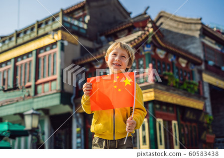 Enjoying vacation in China. Young boy with national chinese flag on the background of the old Chinese street. Travel to China concept. Visa free transit 72 hours, 144 hours in China 60583438