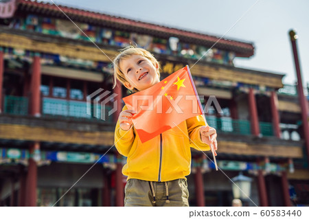 Enjoying vacation in China. Young boy with national chinese flag on the background of the old Chinese street. Travel to China concept. Visa free transit 72 hours, 144 hours in China 60583440