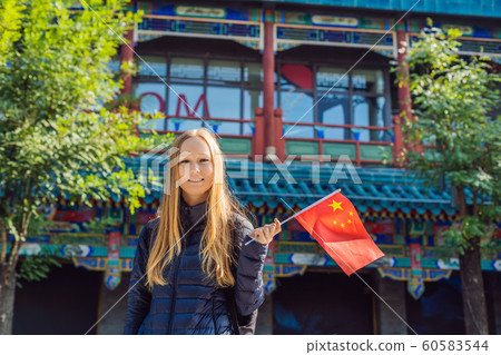 Enjoying vacation in China. Young woman with national chinese flag on the background of the old Chinese street. Travel to China concept. Visa free transit 72 hours, 144 hours in China 60583544