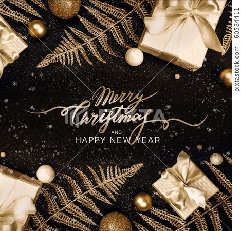 Christmas background. Beautiful holiday card with gifts, Christmas decor and shiny branches on a black background with glitters. Lettering Christmas background. Beautiful holiday card with gifts, Christmas decor and shiny branches on a black background with glitters. Lettering 60584411