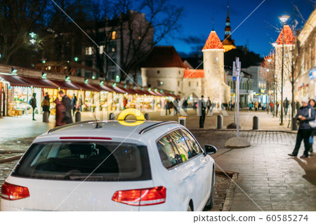 Tallinn, Estonia. Taxi Car Parking Near Viru Gates Entrance To Old Part Town Estonian Capital. Famous Landmark Viru Gate In Street Lighting At Evening Night Illumination. Christmas, Xmas, New Year 60585274