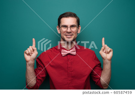 Portrait of a cute young man showing fingers on a green background Portrait of a cute young man showing fingers on a green background 60587459