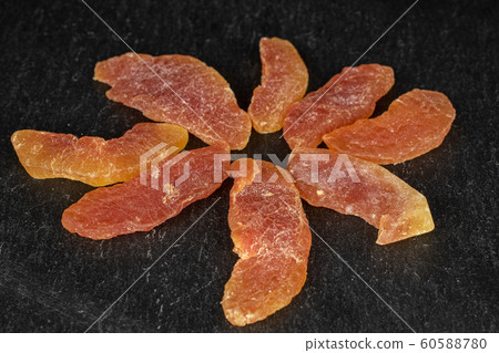 Dried orange papaya on grey stone 60588780
