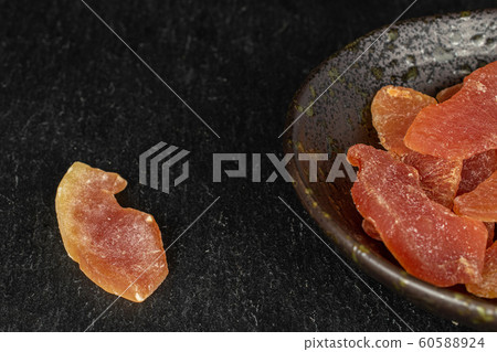Dried orange papaya on grey stone 60588924