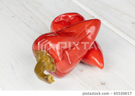Hot pickled pepper on grey wood Hot pickled pepper on grey wood 60589657