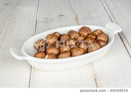 Tasty brown hazelnut on grey wood Tasty brown hazelnut on grey wood 60589919