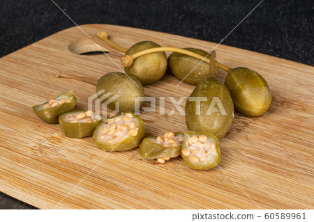 Green pickled caper on grey stone 60589961