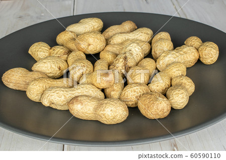 Tasty beige peanut on grey wood 60590110