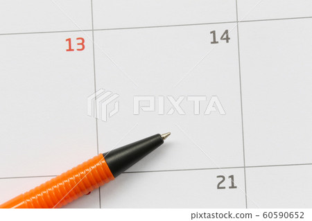 Orange pen is placed on the calendar in the 14th day and have copy space. Orange pen is placed on the calendar in the 14th day and have copy space. 60590652