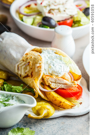 Chicken gyro pita with vegetables and tzatziki 60591058