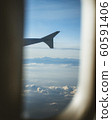 View from cabin of airplane.Through the window. Plane photography above clouds and mountains. 60591406