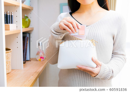 一個把化妝品放在小袋裡的女人 一個把化妝品放在小袋裡的女人 60591836