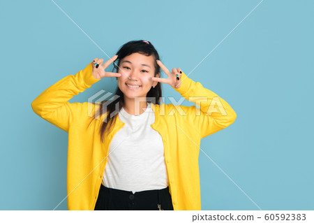 Asian teenager's portrait isolated on blue studio background 60592383