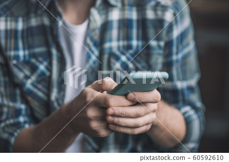 Man holding a smartphone in a blue case. 60592610