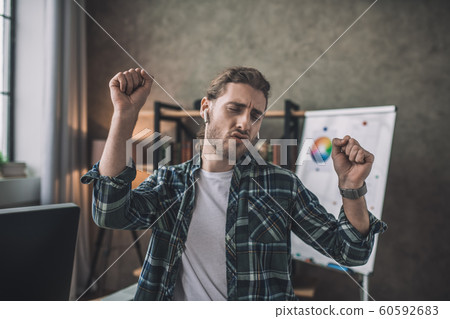 Emotional man dancing while listening to his favourite music Emotional man dancing while listening to his favourite music 60592683
