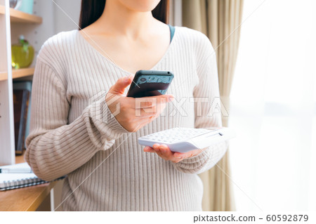 一個看著智能手機時計算的女人 一個看著智能手機時計算的女人 60592879