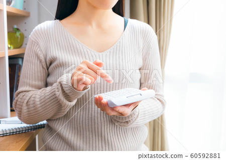 A woman to calculate with a calculator 60592881