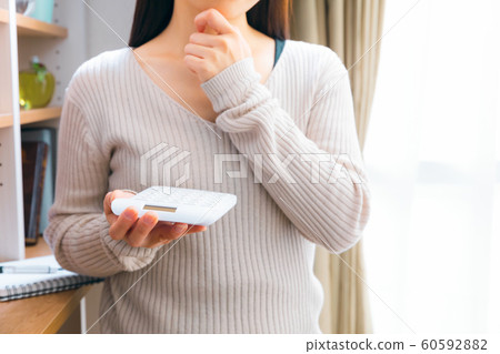 Thinking woman with a calculator 60592882