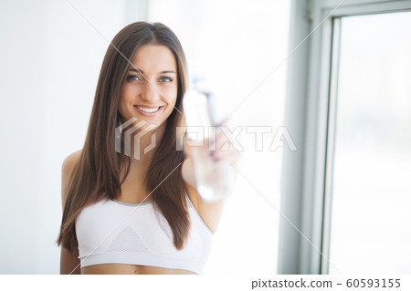 Healthy lifestyle. Beautiful fit young woman holding a bottle of water 60593155
