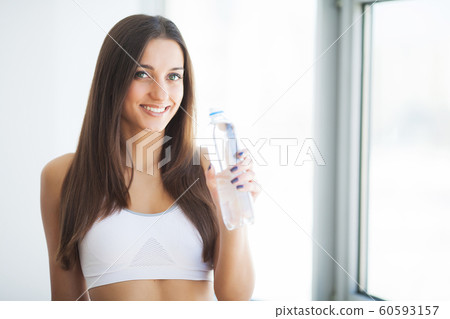 Healthy lifestyle. Beautiful fit young woman holding a bottle of water 60593157