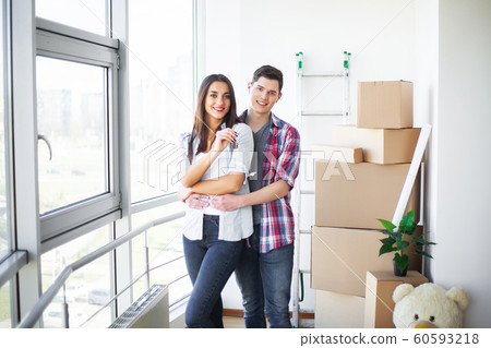 New Home. Funny young couple enjoy and celebrating moving to new home. Happy couple at empty room of new home 60593218