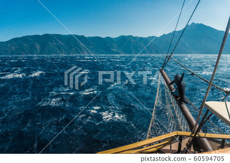 Waves on the sea and the mast of the ship in Greece 60594705