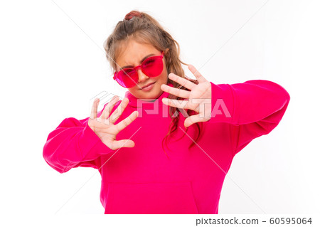 Fashionable teenager girl in pink hoody and with pink sunglasses gesticulates, portrait isolated on Fashionable teenager girl in pink hoody and with pink sunglasses gesticulates, portrait isolated on 60595064