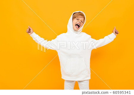 attractive blond boy in a white hoodie screaming out loud on an orange background attractive blond boy in a white hoodie screaming out loud on an orange background 60595341