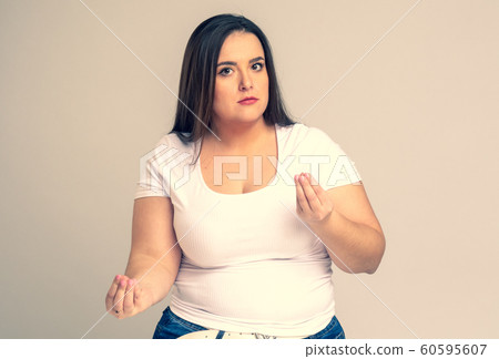 Plus Size Model with long hair meditates in studio. 60595607