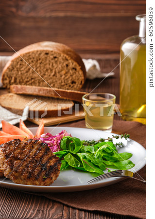 Grilled beef cutlet with fresh salad, brown bread Grilled beef cutlet with fresh salad, brown bread 60596039