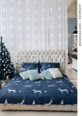 Tidy bed with Christmas tree and garland. Tidy bed with Christmas tree and garland. 60596297