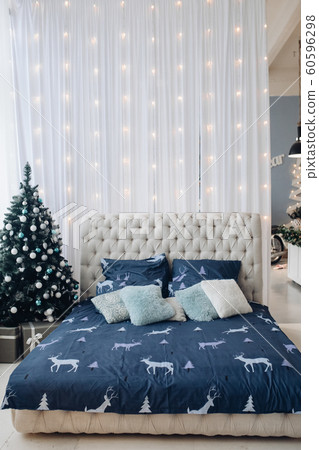 Tidy bed with Christmas tree and garland. Tidy bed with Christmas tree and garland. 60596298