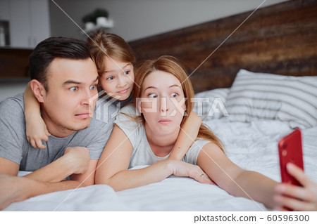 leisure time of emotional caucasian family lying on bed leisure time of emotional caucasian family lying on bed 60596300