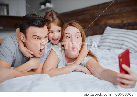 emotional happy family with daughter on bed emotional happy family with daughter on bed 60596303